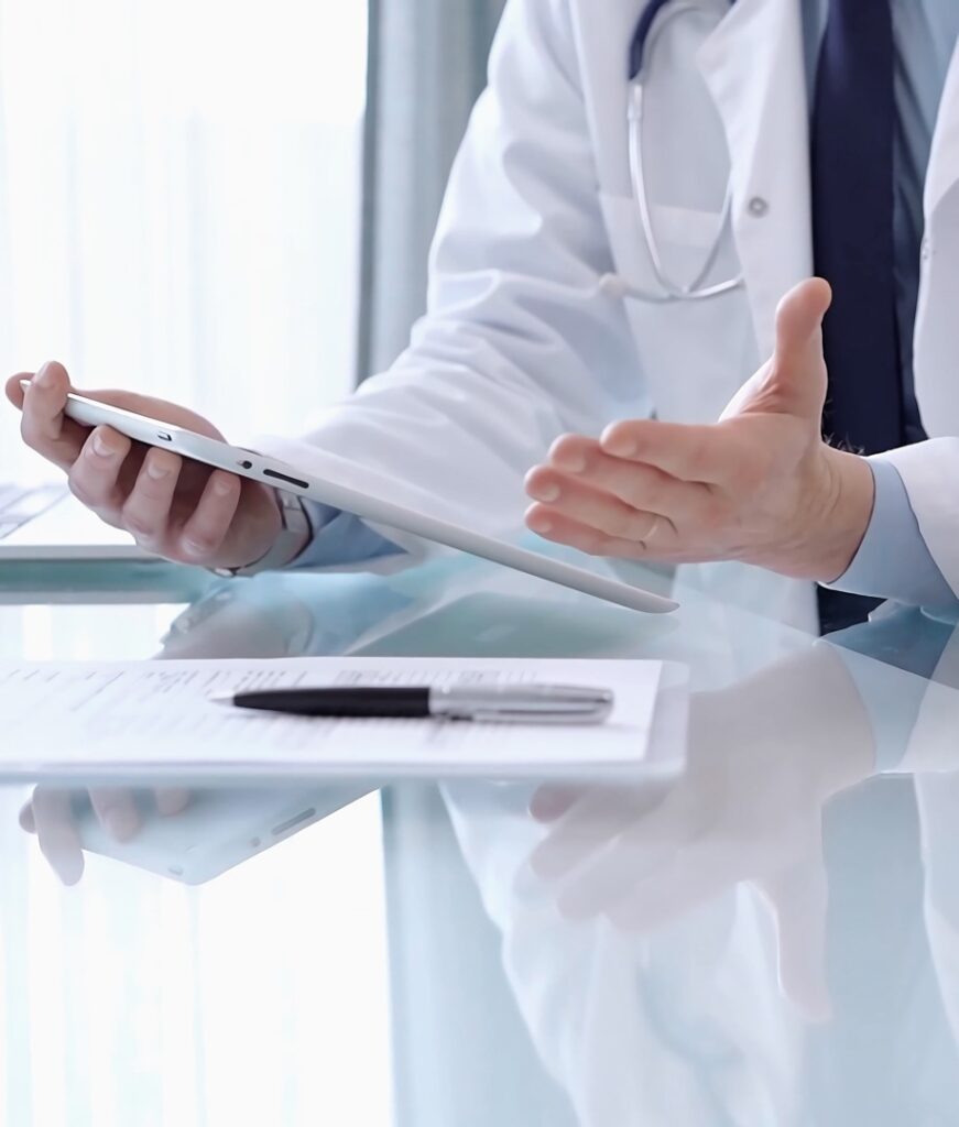 Doctor is consulting patient in modern clinic. Healthcare professional discusses medical information with a woman, using a tablet computer. Medicine concept